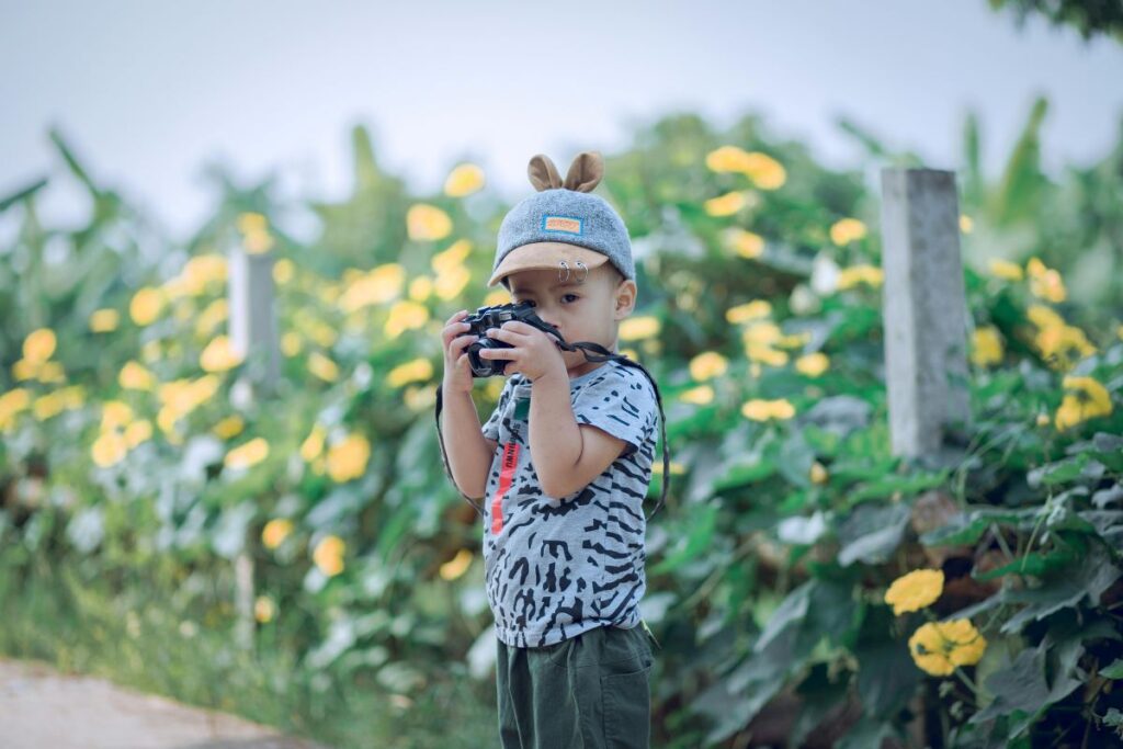 Young boy in front of yellow flowers