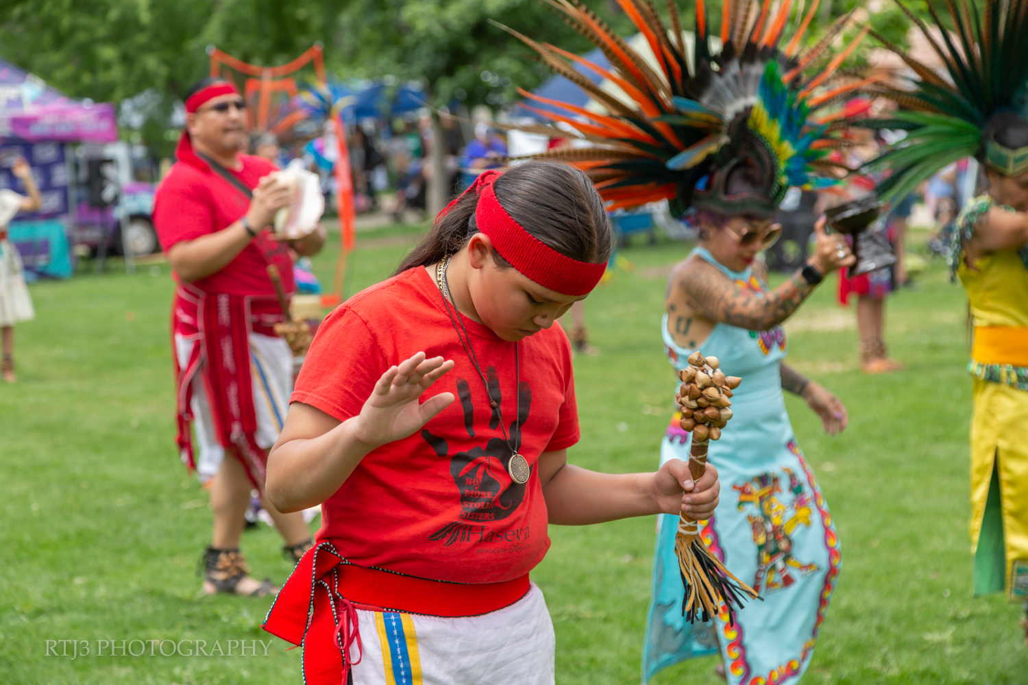 criança participando de dança nativa americana durante evento