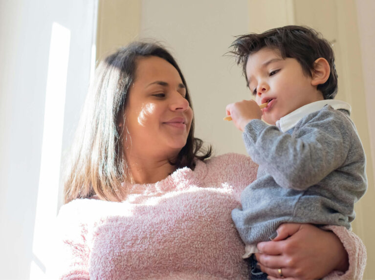 Mother holding son in her arms while looking at him.