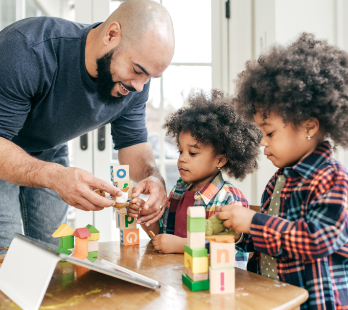Father playing blocks with two young sons