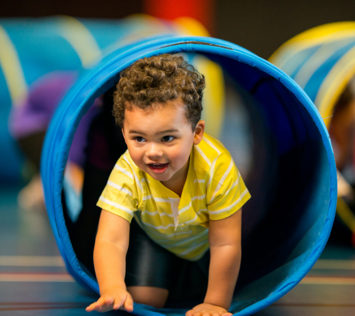 Jeune garçon rampant dans un tunnel de jeu